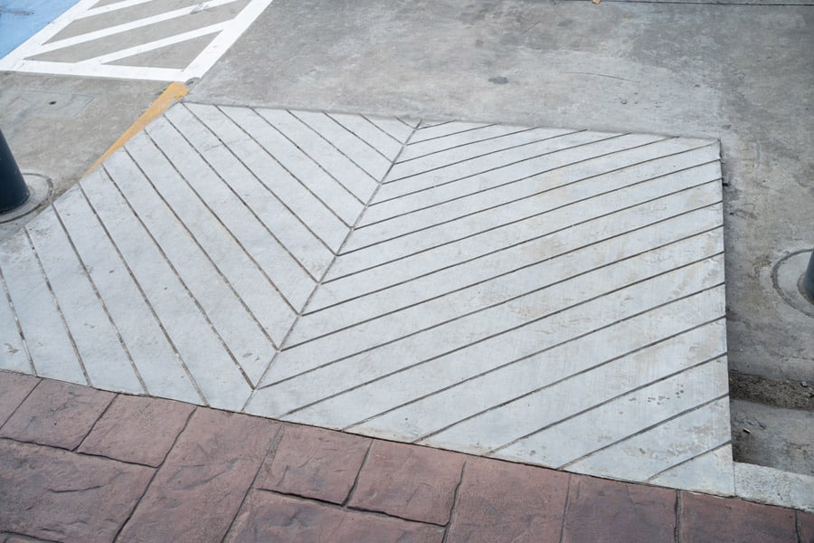 A newly installed concrete ADA ramp for a commercial building